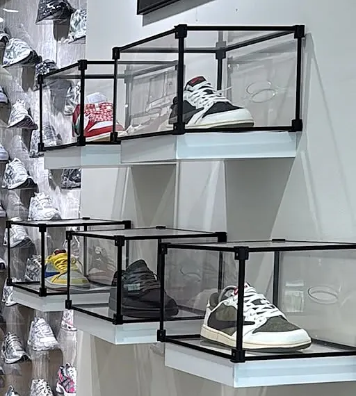 Sneakers in glazen vitrines aan de muur van de winkel